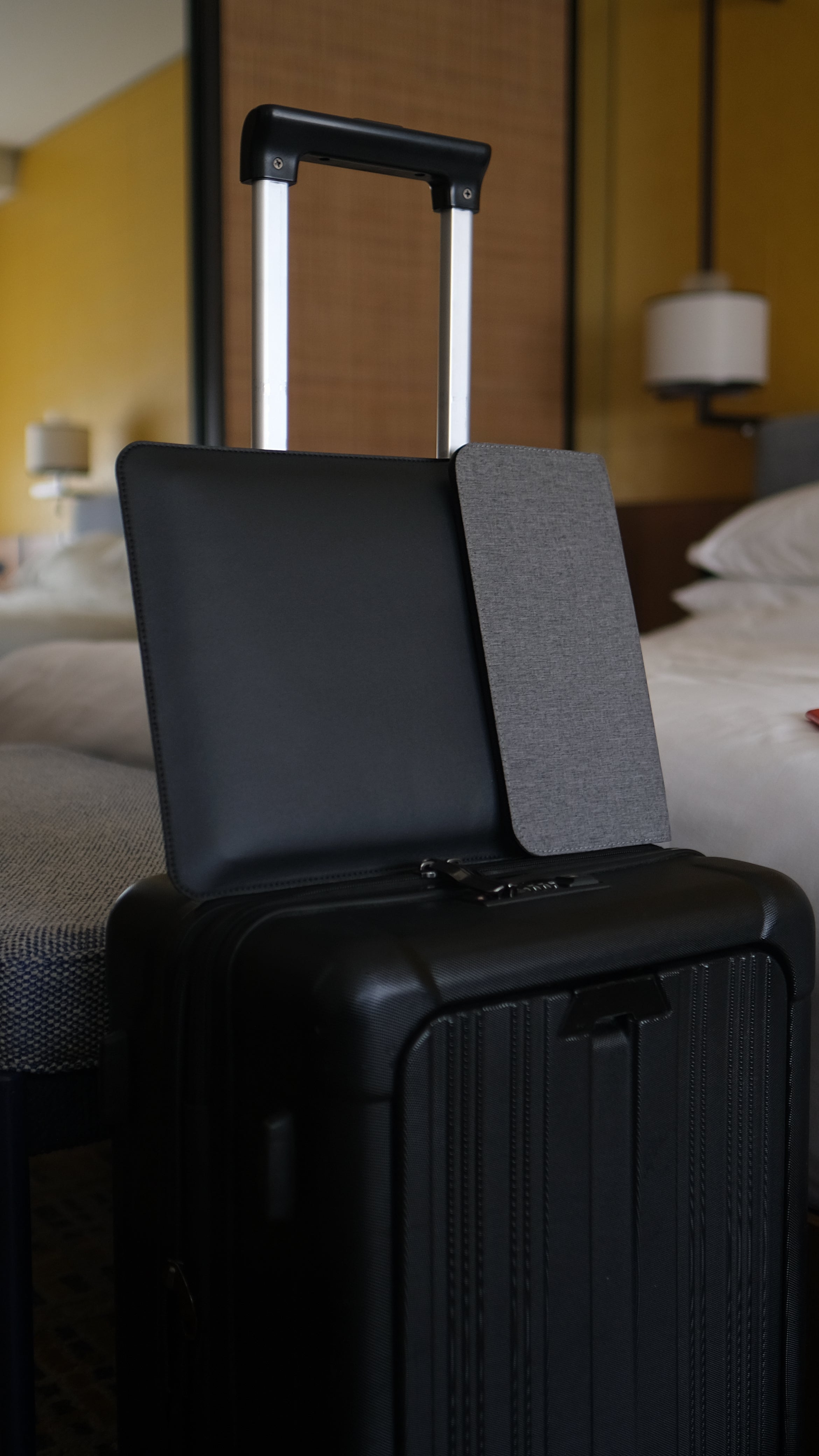 NODE laptop sleeve sat atop a black suitcase in a hotel room in New Delhi